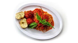 A plate of spaghetti with marinara sauce and meatballs